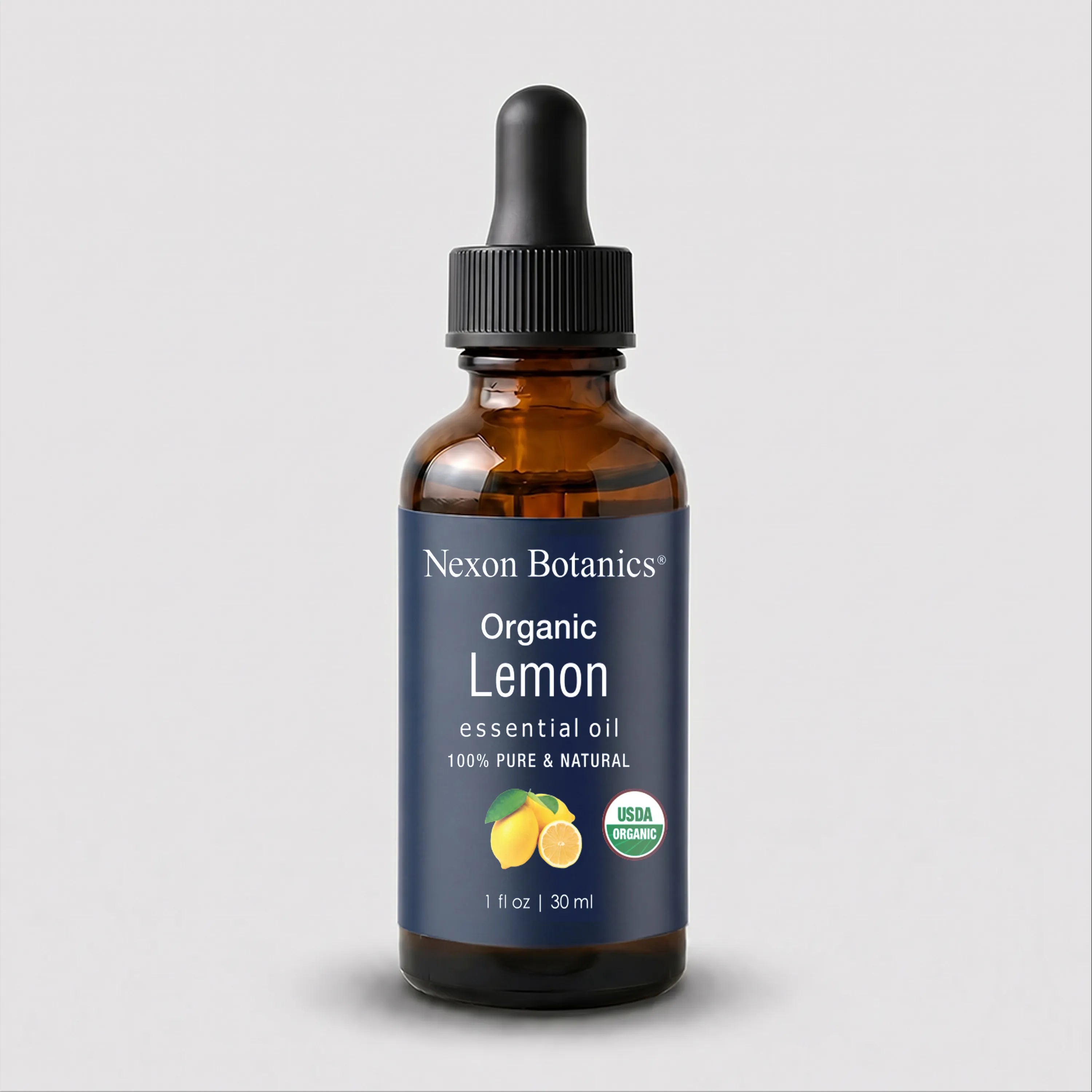 A 30 ml amber glass dropper bottle of Nexon Botanics Organic Lemon essential oil, featuring a dark blue label with white text and a black dropper cap, set against a light gray background.