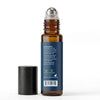 An amber glass rollerball bottle with a dark blue label and a silver cap, shown next to a separate black cap on a white background.