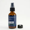 An amber glass spray bottle with a dark blue label and a black spray nozzle, shown with its detached black cap on a clean white background.