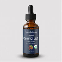A 30 ml amber glass dropper bottle of Nexon Botanics Organic Cinnamon Leaf essential oil, featuring a dark blue label and a black dropper cap, set against a light gray background.
