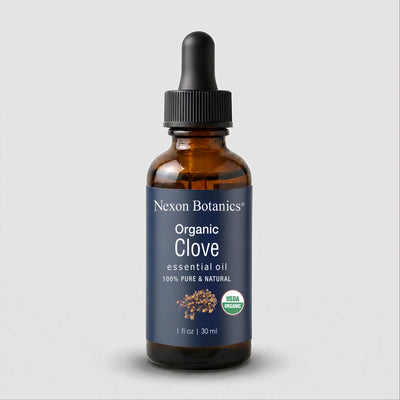 Nexon Botanics Organic Clove essential oil in a 1 fl oz amber glass dropper bottle with a dark blue label and black dropper cap, shown on a light gray background.
